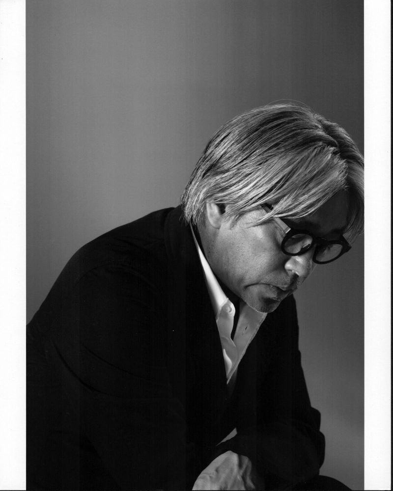 Black and white photo print of Ryuichi Sakamoto looking down.