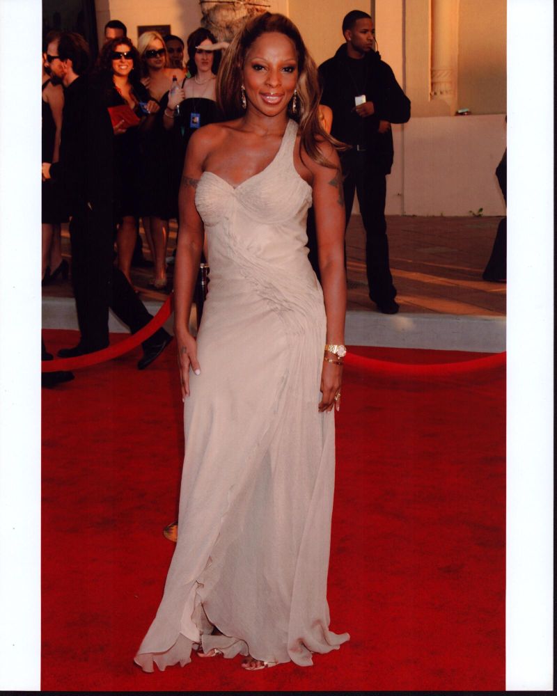 Mary J. Blige wearing a tan one shoulder gown in a photo print.
