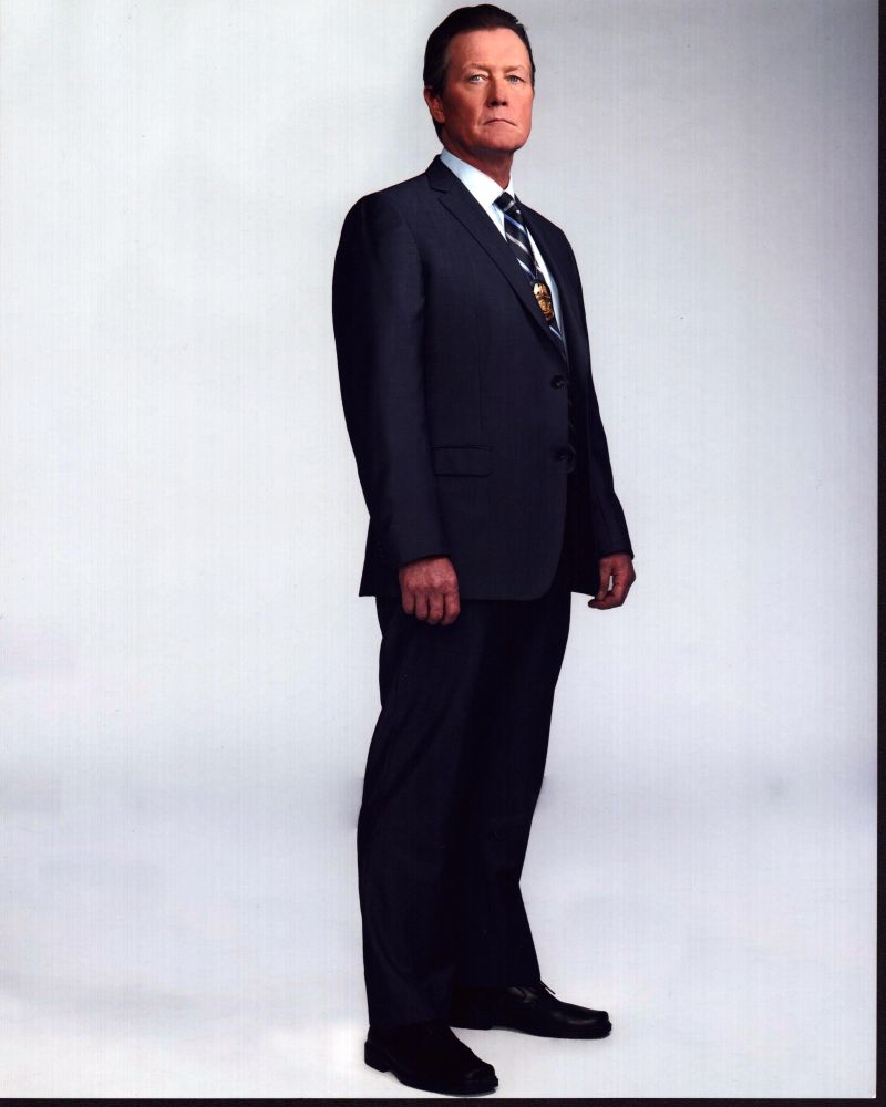 Robert Patrick wearing a badge in a navy suit photo print