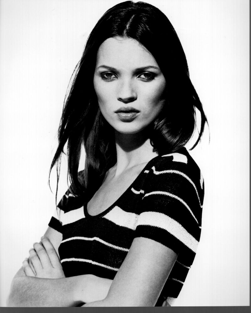 Black and white photo print of Kate Moss with arms crossed in striped shirt.