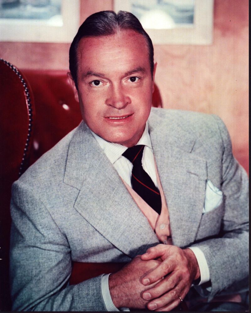 Bob Hope wearing a gray blazer sitting in a red chair photo print