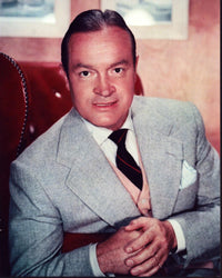 Bob Hope wearing a gray blazer sitting in a red chair photo print