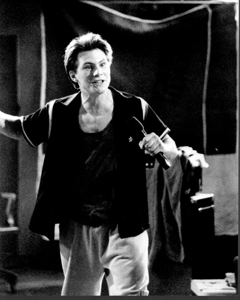 Black and white photo print of Christian Slater wearing sweatpants with a microphone.