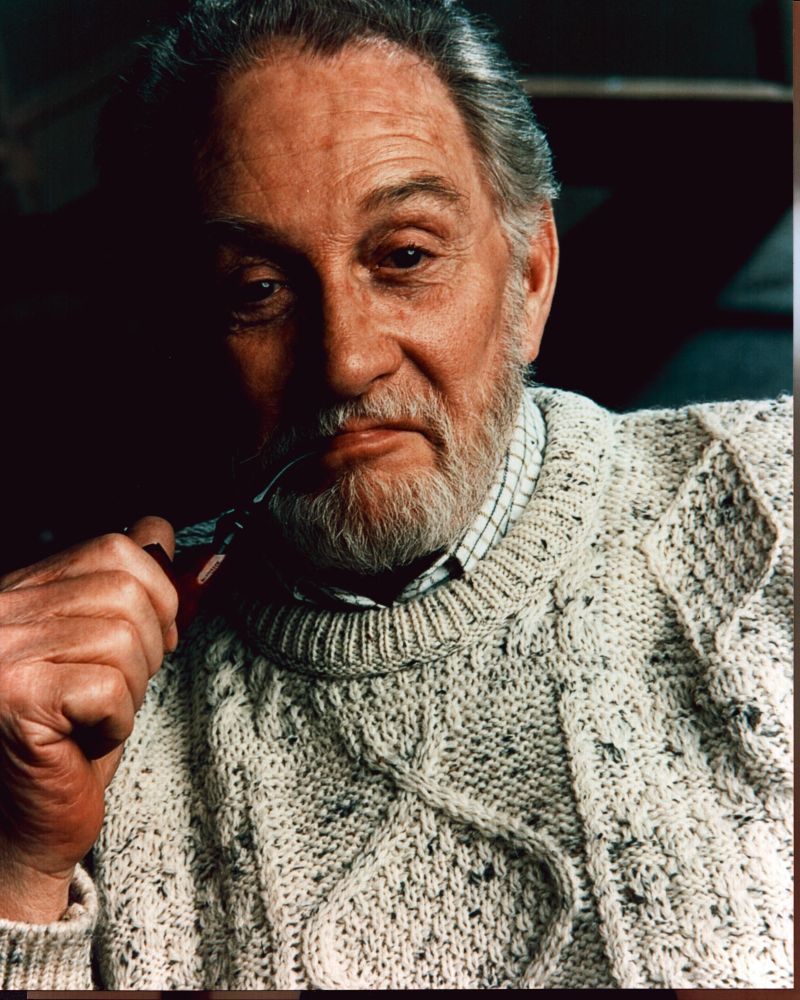 Roy Dotrice photo print in cable knit sweater with pipe.