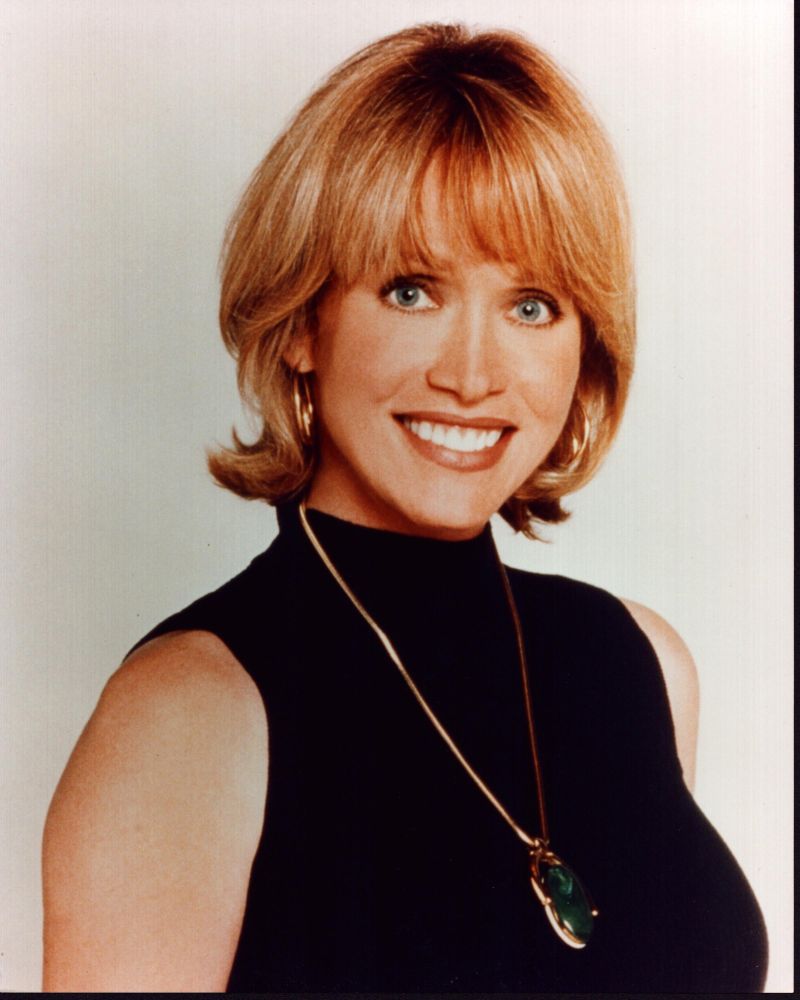 Tanya Roberts photo print in sleeveless black turtleneck with gold necklace.