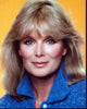 Linda Evans headshot photo print in blue sweater with yellow background.