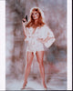 Tanya Roberts in silk shorts outfit holding a gun photo print.