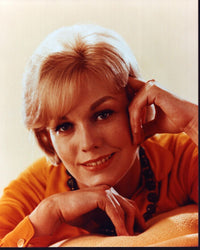 Kim Novak leaning on hands in orange shirt photo print.