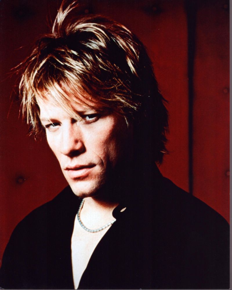 Jon Bon Jovi photo print with black top against red background.