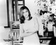 Jennifer Aniston black and white photo print with arms crossed next to flowers.