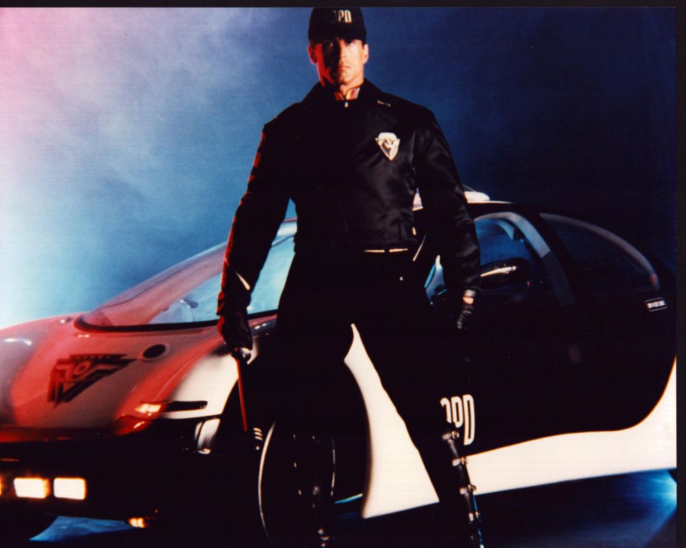 Sylvester Stallone in front of a cop car from Demolition Man photo print.