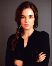 Zoey Deutch photo print in black sweater with arms crossed.