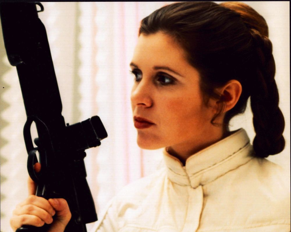 Carrie Fisher as Princess Leia holding a gun in Star Wars: Episode V - The Empire Strikes Back photo print.