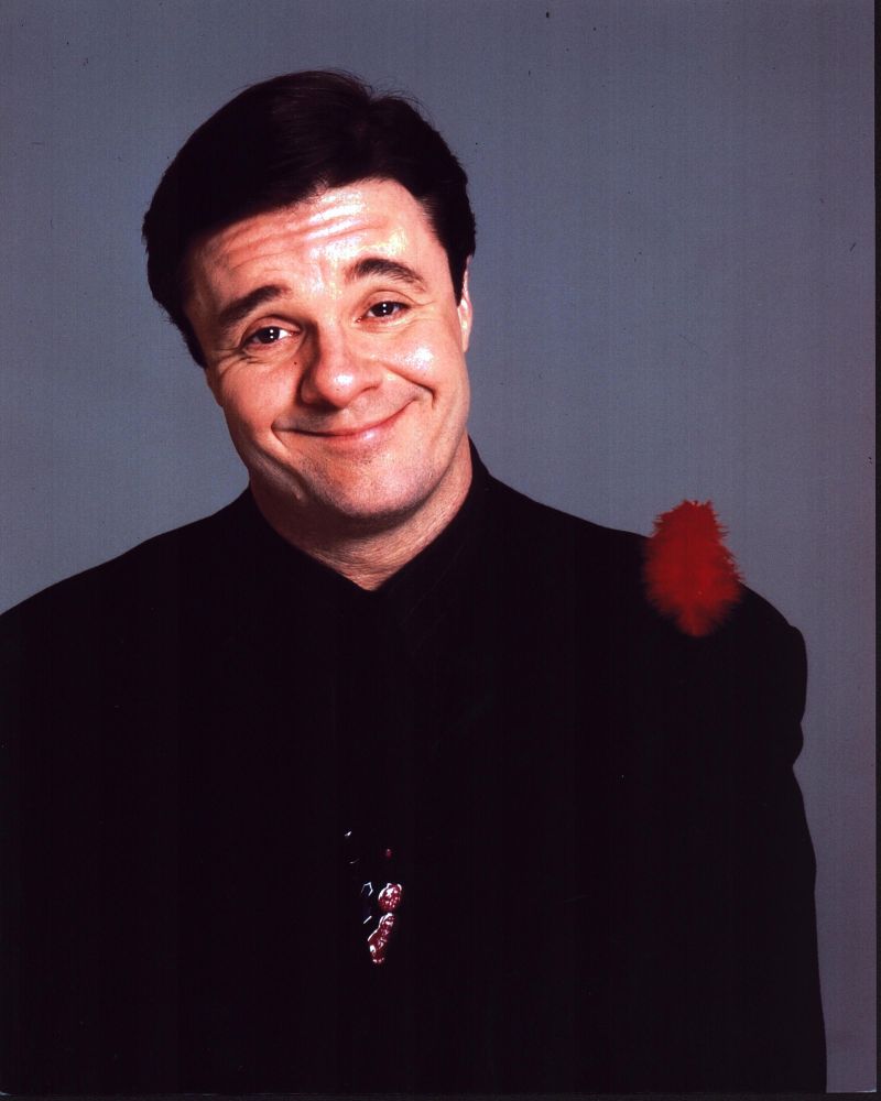 Nathan Lane in black suit with red feather photo print.