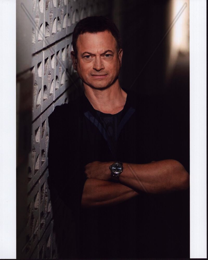 Gary Sinise leaning against a wall, arms crossed - photo print