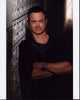 Gary Sinise leaning against a wall, arms crossed - photo print