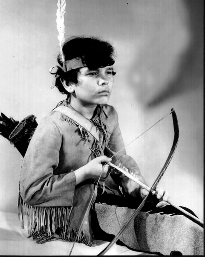 Black and white photo of Tommy Cook in costume with bow and arrow