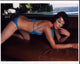 Milla Jovovich lounging on a couch in a blue swimsuit photo print