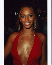 Beyoncé stunning photo print in low cut red top and diamond necklace.