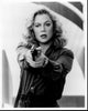 Black and white photo print of Kathleen Turner as V.I. Warshawski, showcasing her iconic pose with a gun.