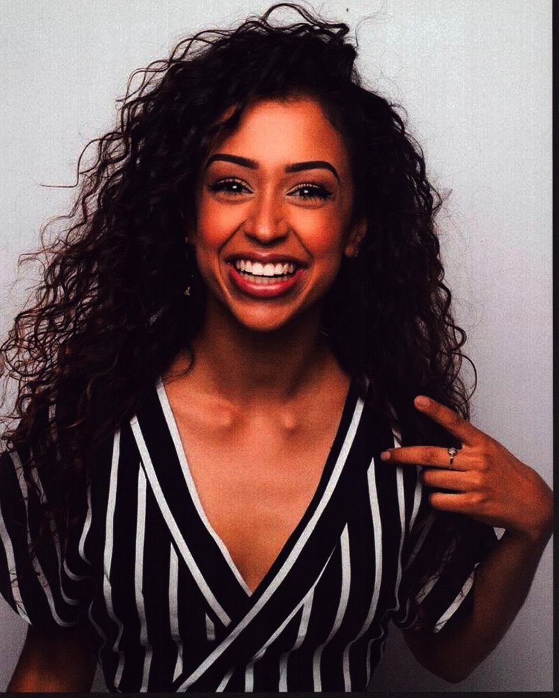 Liza Koshy smiling in a black and white striped top photo print.