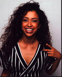 Liza Koshy smiling in a black and white striped top photo print.
