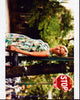 Mickey Sumner leaning against a street sign in a floral dress photo print