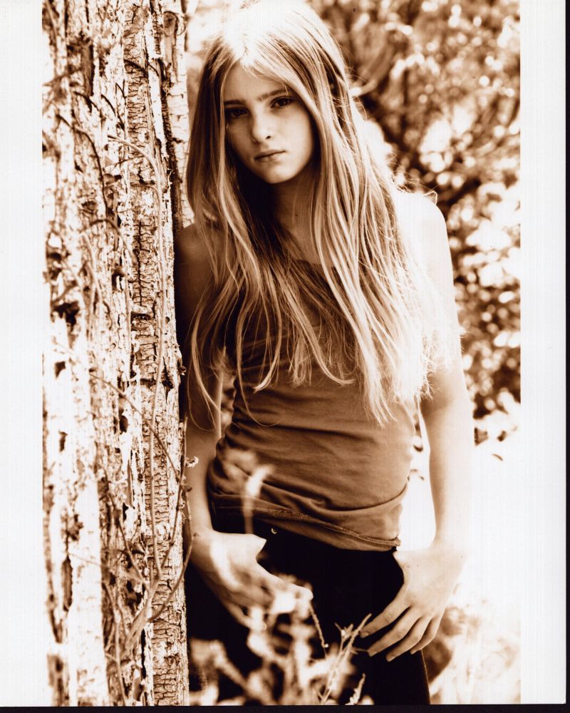 Willow Shields leaning on tree photo print showcasing serene nature beauty.