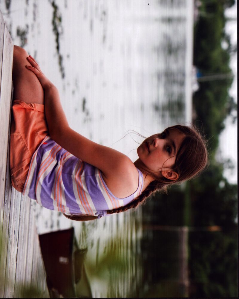 Sterling Jerins Sitting On Dock Photo Print showcasing tranquility and reflection.