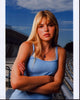Aimee Teegarden in blue tank top photo print, arms crossed.