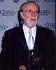 George Carlin photo print holding American Comedy Award in suit.