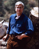 Leslie Nielsen leaning on a tree trunk photo print.