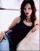 Amber Tamblyn sitting on couch in jeans and tank top photo print, stylish lifestyle portrait.