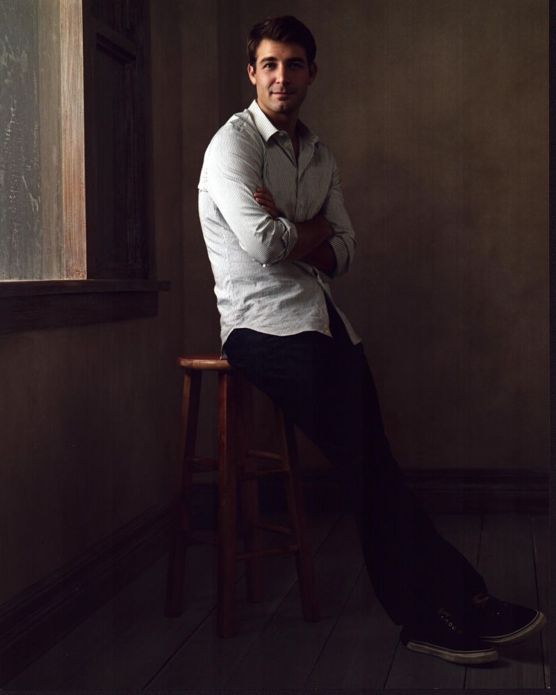 James Wolk Leaning On Stool Photo Print capturing the actor's charisma.