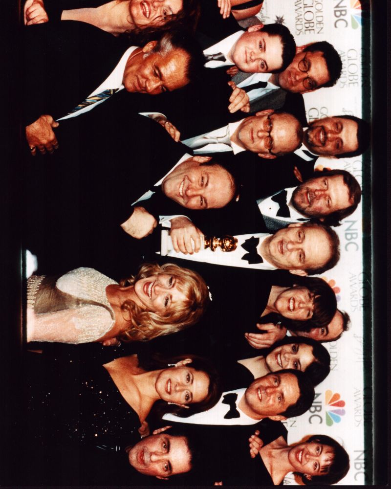 David Chase holding Golden Globe with The Sopranos cast photo print.