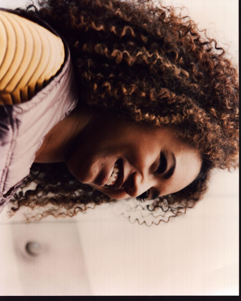 Close-up photo print of Mel B in a purple vest.