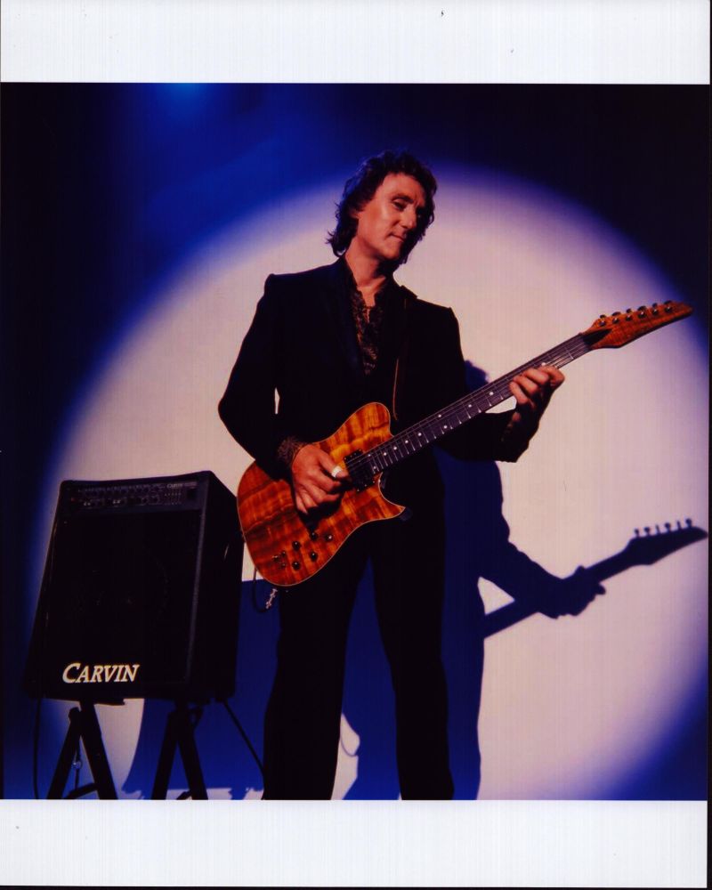 Denny Laine Playing Guitar Photo Print - Captivating image of guitarist in action.