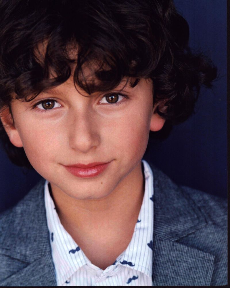 August Maturo photo print in striped shirt and gray blazer.