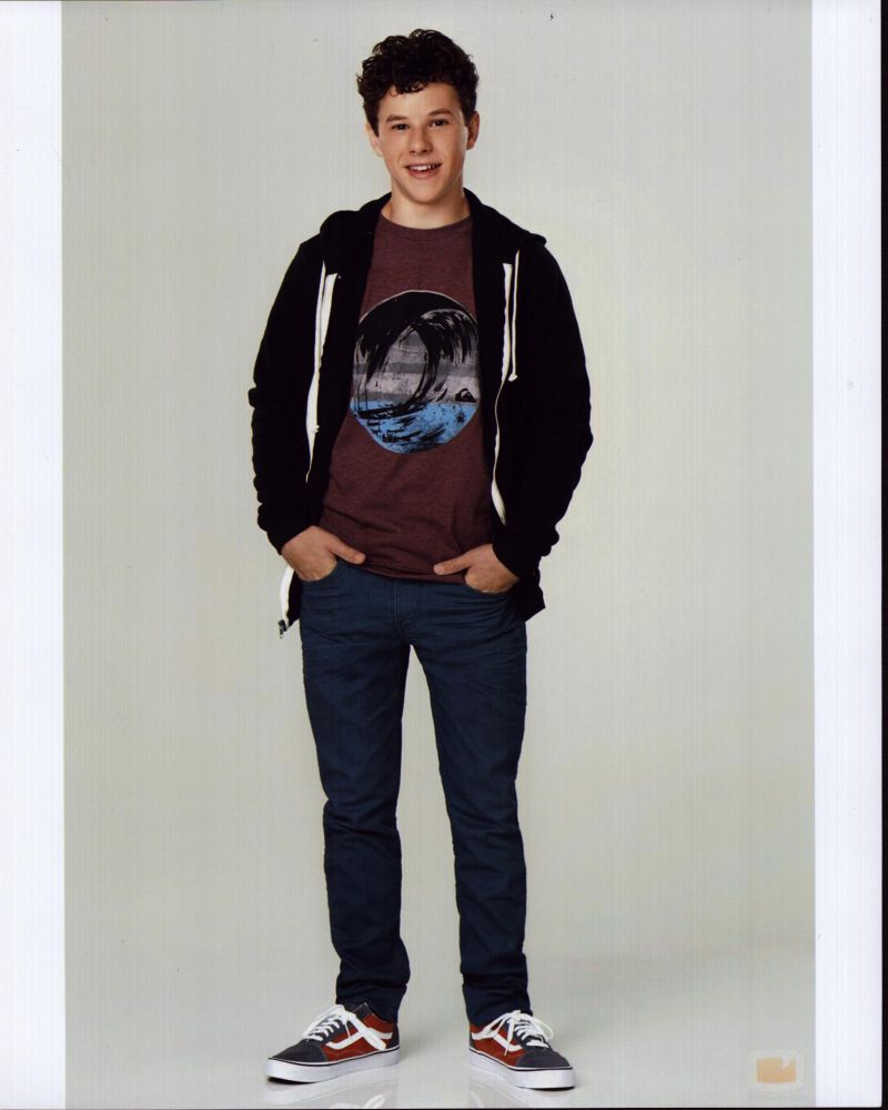 Nolan Gould photo print in jeans and sweatshirt with hands in pockets.