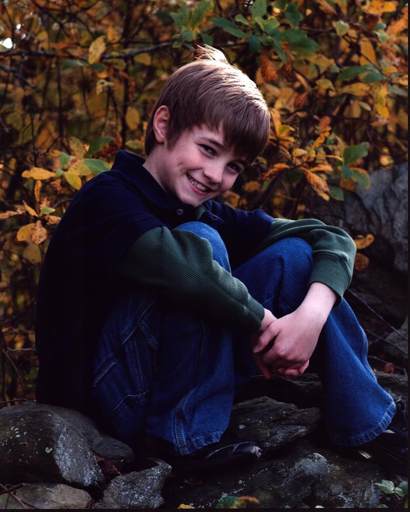 Cj Adams headshot photo print sitting on rocks.