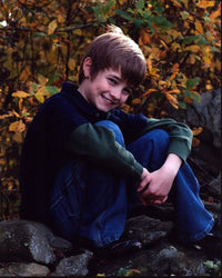 Cj Adams headshot photo print sitting on rocks.