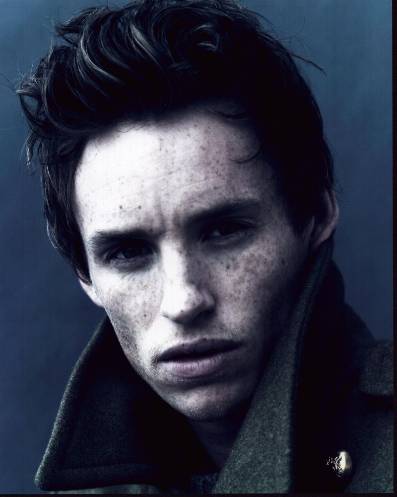 Eddie Redmayne headshot in a stylish jacket with collar up.