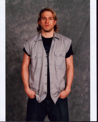 Charlie Hunnam stylish photo print in tan top with hands in pockets.