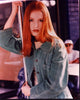 Alicia Witt leaning on pole in green jacket photo print