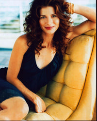 Debra Messing seated in a yellow padded chair photo print
