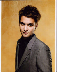 Luke Grimes photo print in gray suit with yellow background.