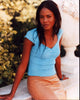 Tangi Miller sitting on a wall wearing a blue top - Photo Print