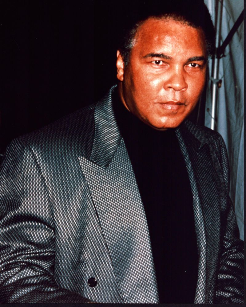 Muhammad Ali photo print in gray blazer and black shirt, capturing the essence of the boxing legend.