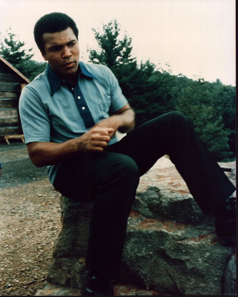 Muhammad Ali sitting on rock photo print, iconic sports image.