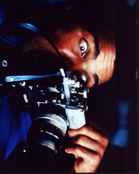Muhammad Ali holding a camera photo print, iconic sports moment.